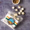 An opened bag of Paneer with cubes coming out of the top. | Featured image for Fresco Cheese.